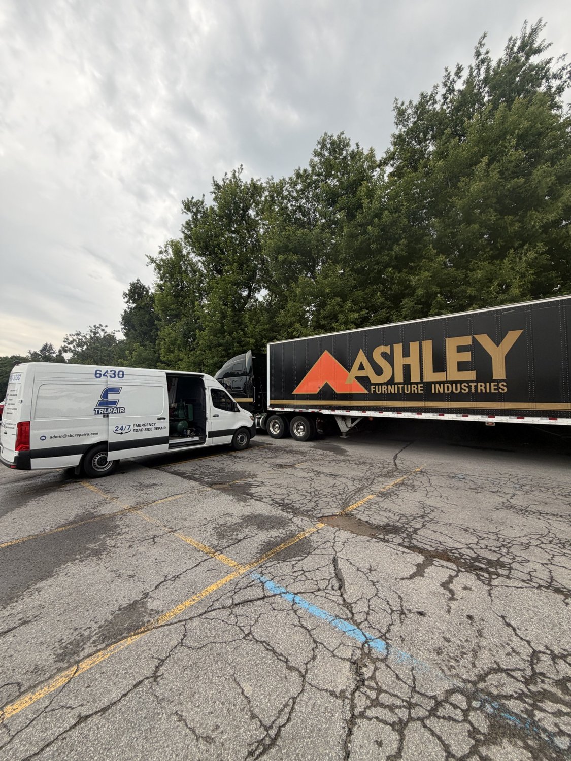 SBC service van with equipment beside Ashley transport trailer